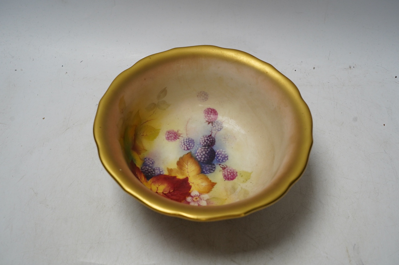 A Worcester bowl hand painted with fruit and leaves by Kitty Blake, 18cm diameter. Condition - good